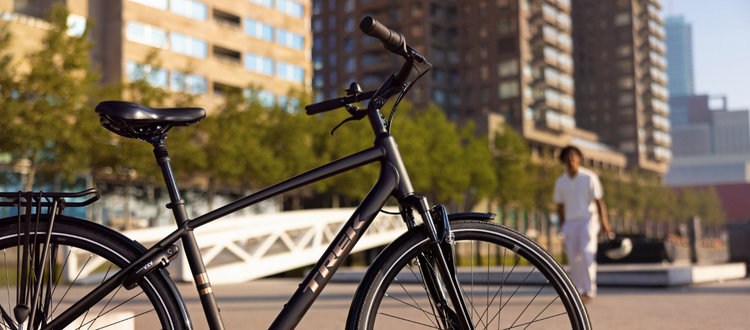 meilleur-velo-hybride-confort-pour-adulte Vélo Trek blanc avec détails noirs sur un fond de brique blanche